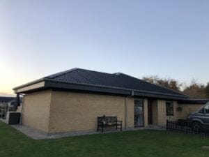 Mursten hus med sort tag i solnedgang