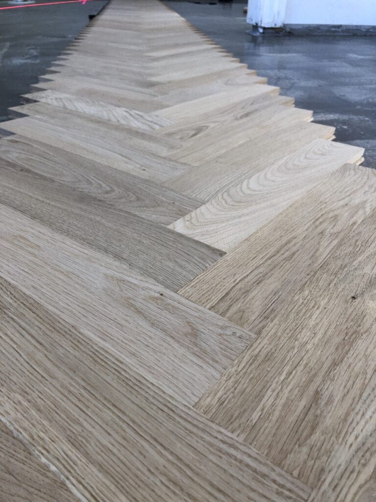 Lyse trægulvbrædder i sildebensmønster